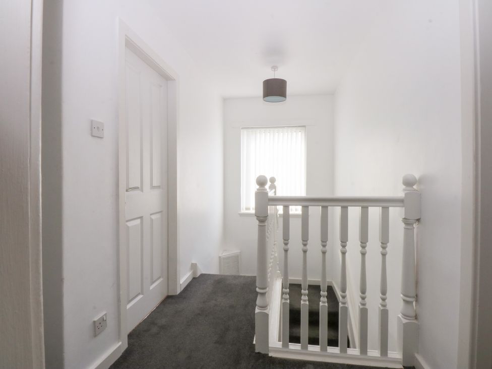 A hallway with a staircase and a window at Seabreeze in Llandudno