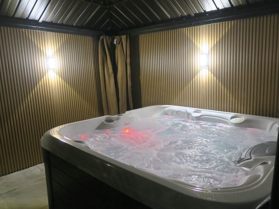 A hot tub with wall and light fixtures at Seabreeze in Llandudno