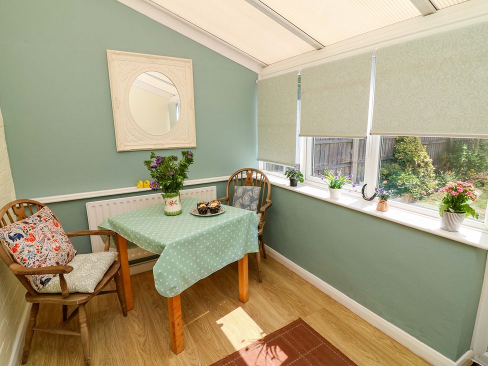 A conservatory with a table and chairs at 37 East Lane in Mansfield