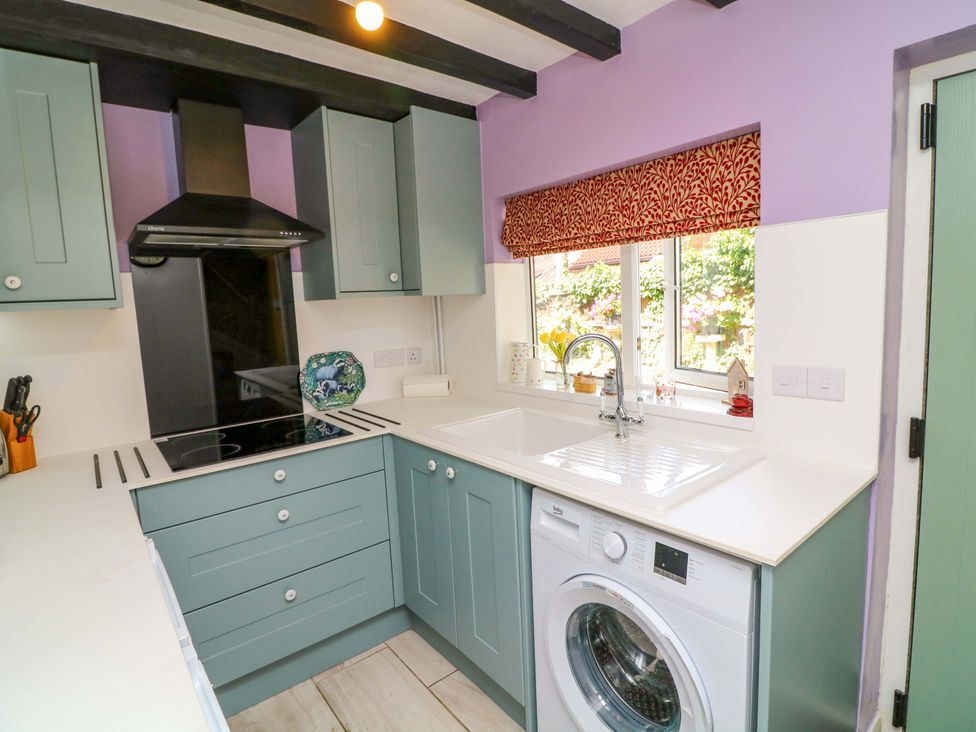 A kitchen with a sink and washing machine at 37 East Lane Mansfield