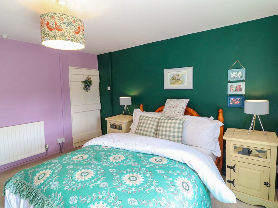 A bedroom with a bed and nightstands at 37 East Lane, Mansfield