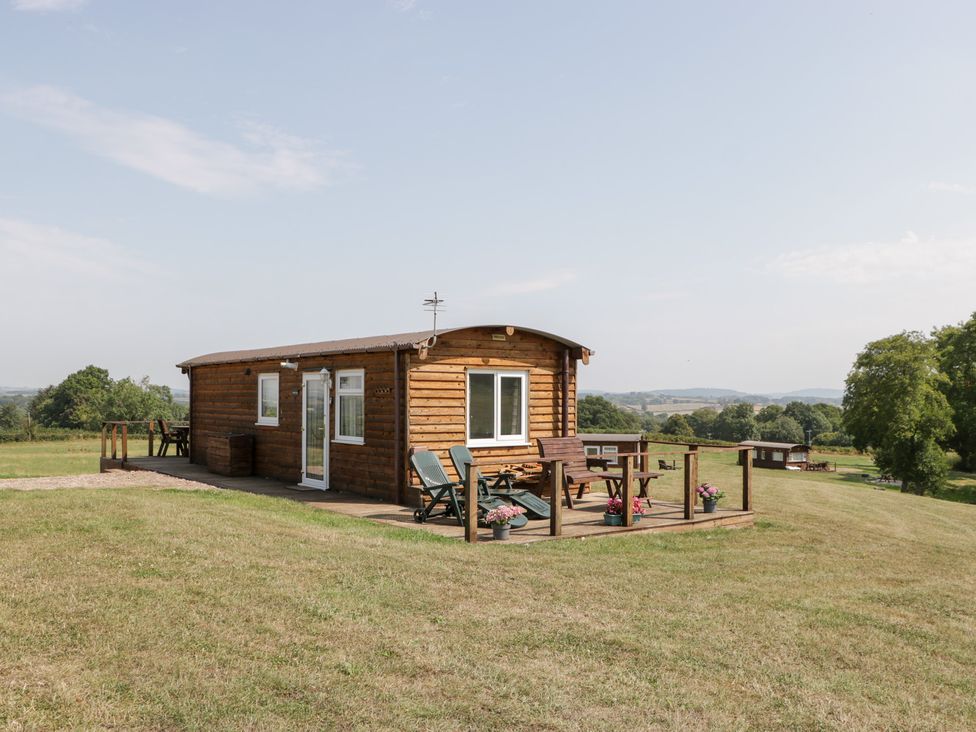 A cabin with a deck and surrounding landscape at Twilight in Raglan