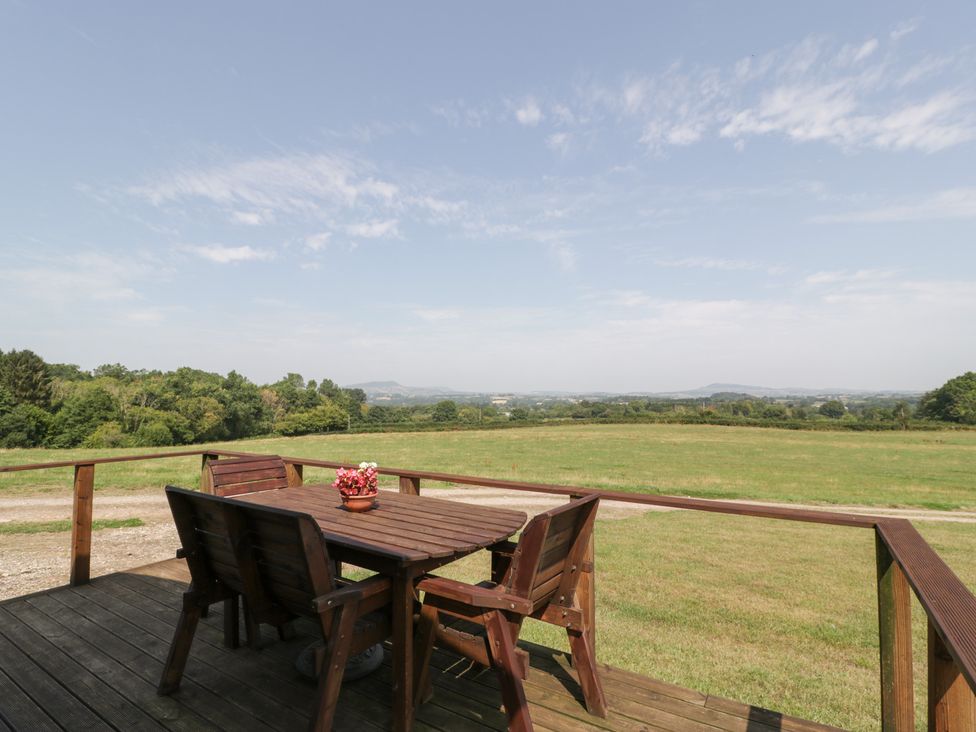 An outdoor seating area with a wooden table and chairs at Twilight in Raglan