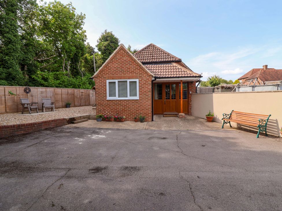 A house with a driveway and bench at Poddington Cottage in 
