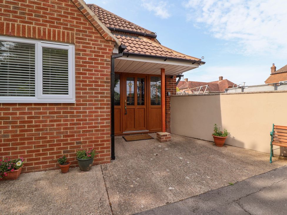 An outdoor area featuring a front door and a bench at Poddington Cottage