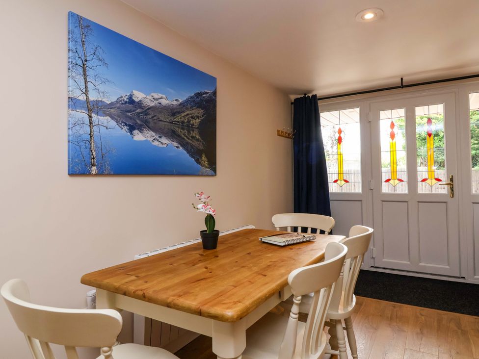 A dining room with a table and chairs at Poddington Cottage