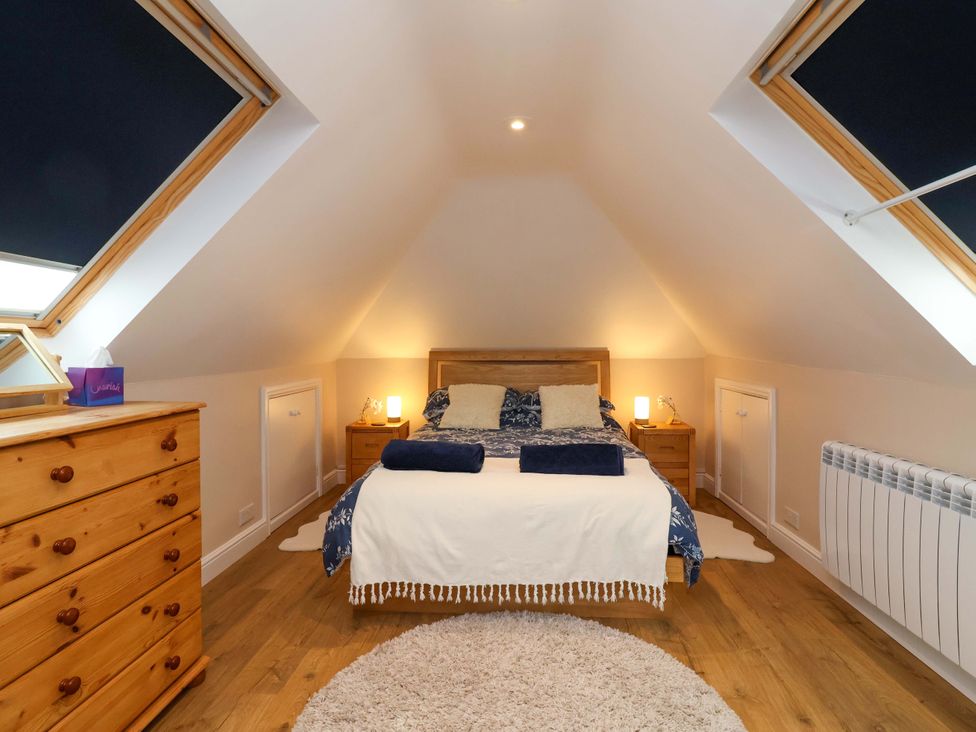A bedroom with a bed and chest of drawers at Poddington Cottage