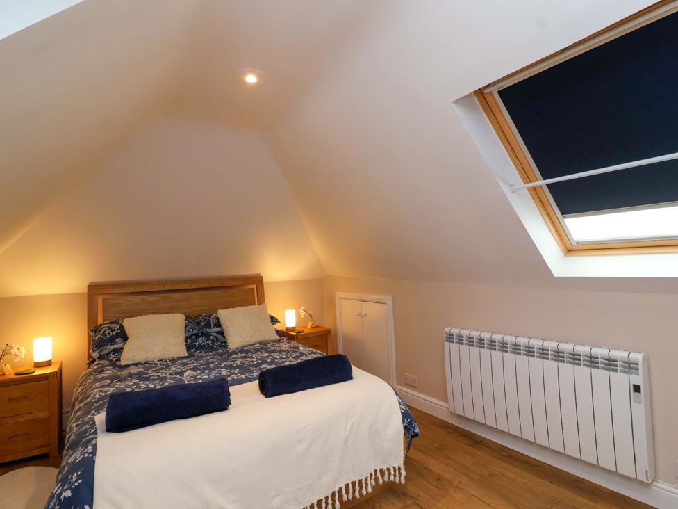 A bedroom with a bed and bedside tables at Poddington Cottage