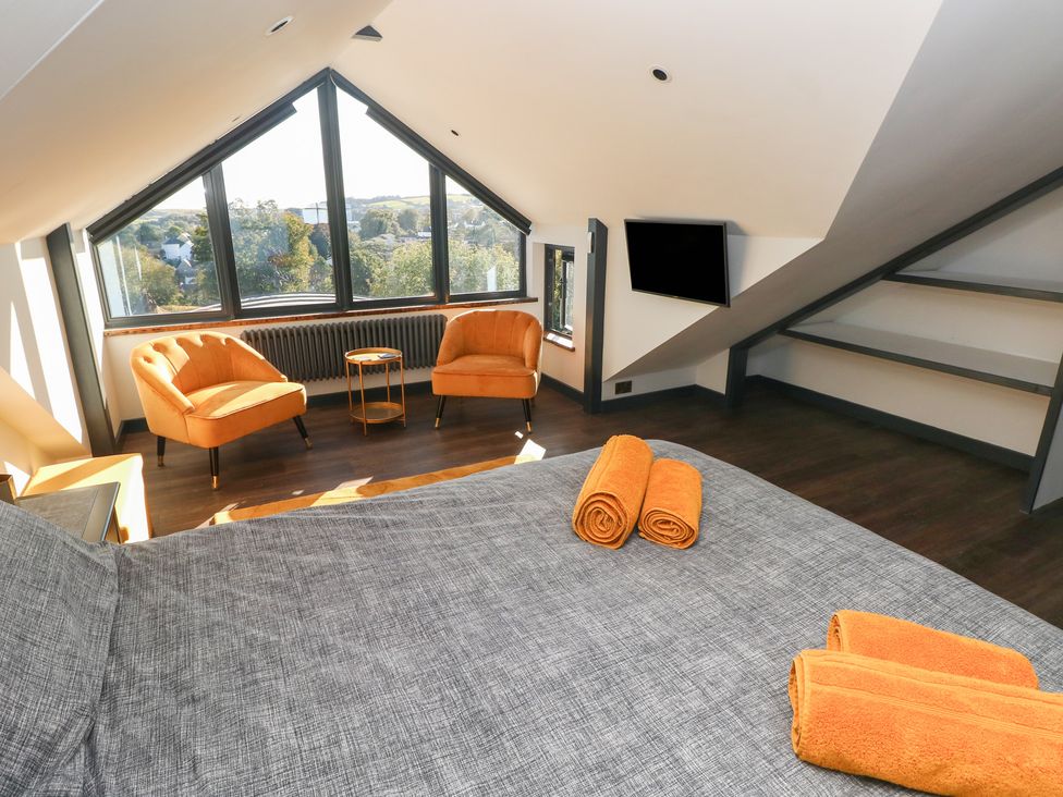 A bedroom with a bed and seating area at 10 Brython Place Tenby