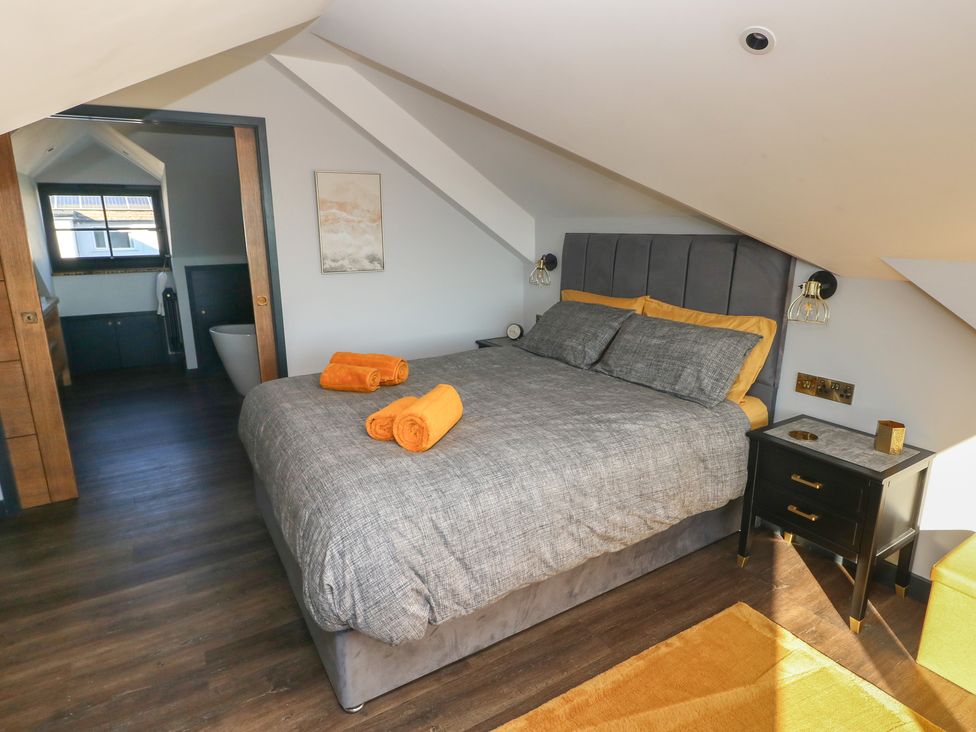A bedroom with a bed and towels at 10 Brython Place in Tenby