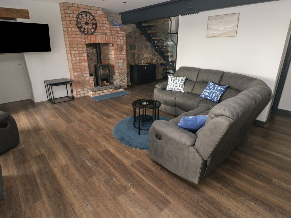 A living room with a sofa and fireplace at 10 Brython Place in Tackley