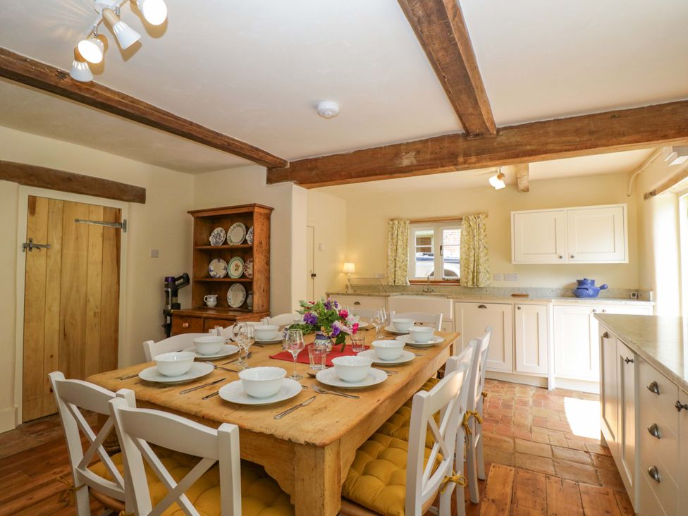 A dining room with a table set for meals at Keepers Cottage in Devizes