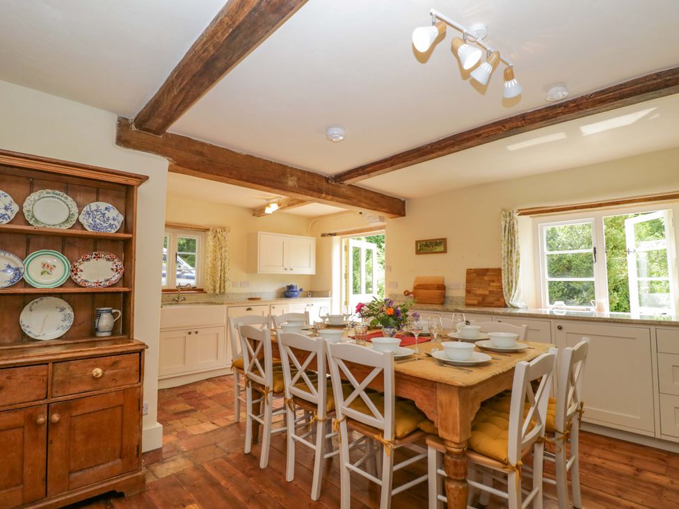 A kitchen with a dining table and chairs at Keepers Cottage in Devizes