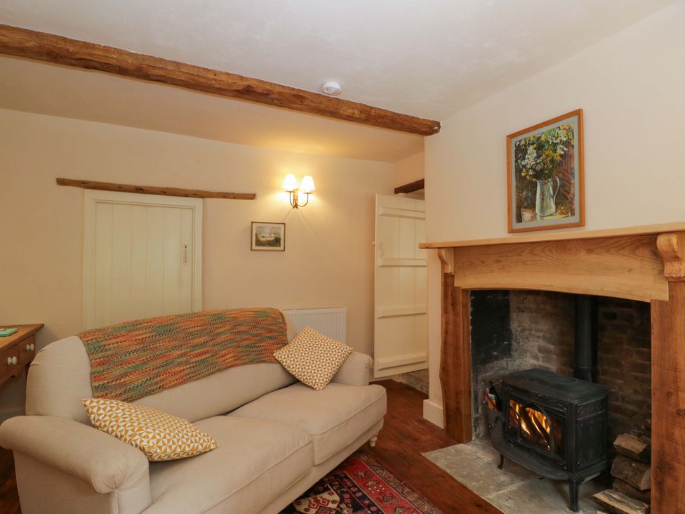 A living room with a sofa and fireplace at Keepers Cottage in Devizes