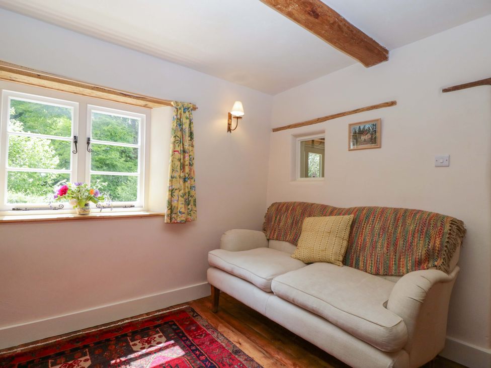 A living room with a sofa and window at Keepers Cottage in Devizes