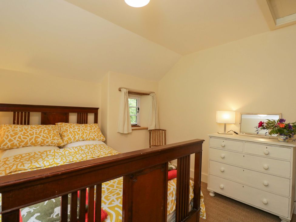 A bedroom with a bed and a dressing table at Keepers Cottage in Devizes