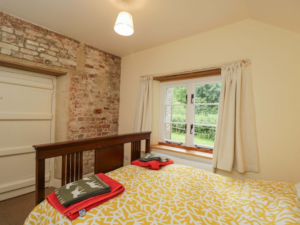 A bedroom with a bed and towels on top at Keepers Cottage in Devizes