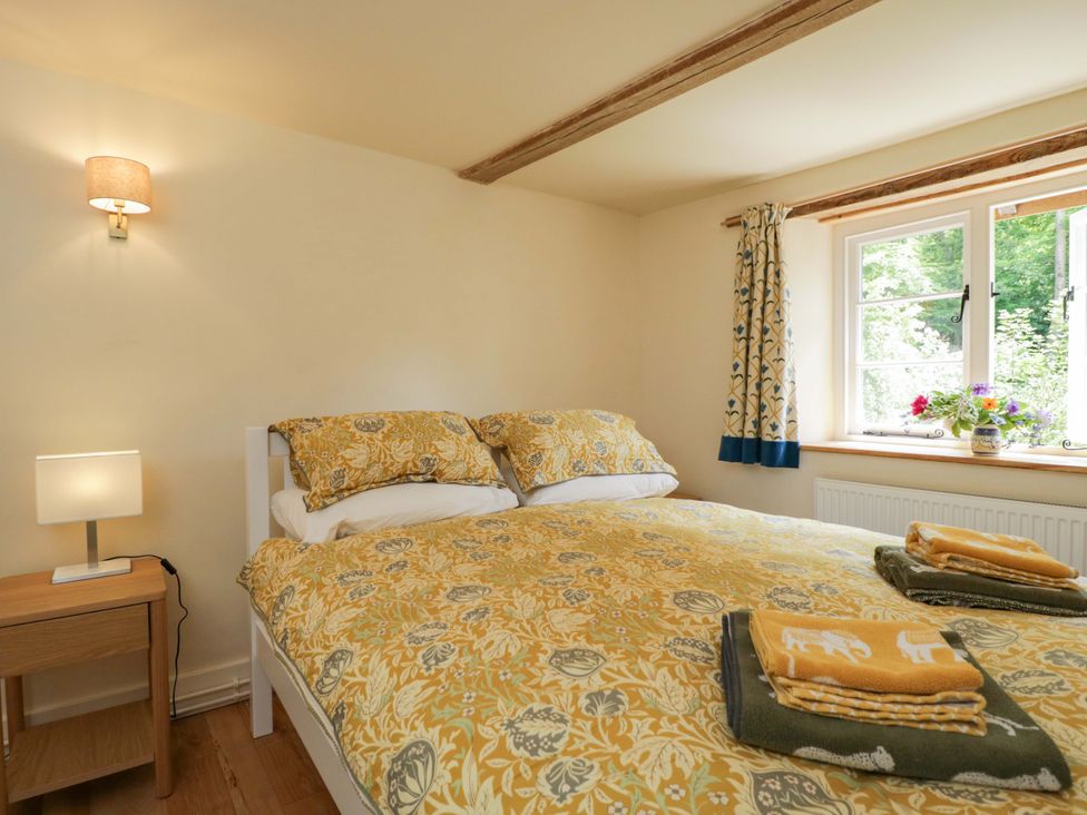 A bedroom with a bed and a window at Keepers Cottage in Devizes