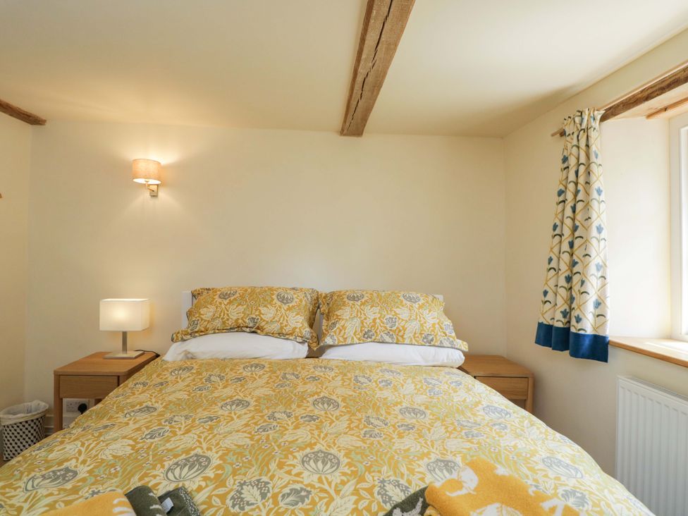A bedroom with a bed and lamp at Keepers Cottage Devizes