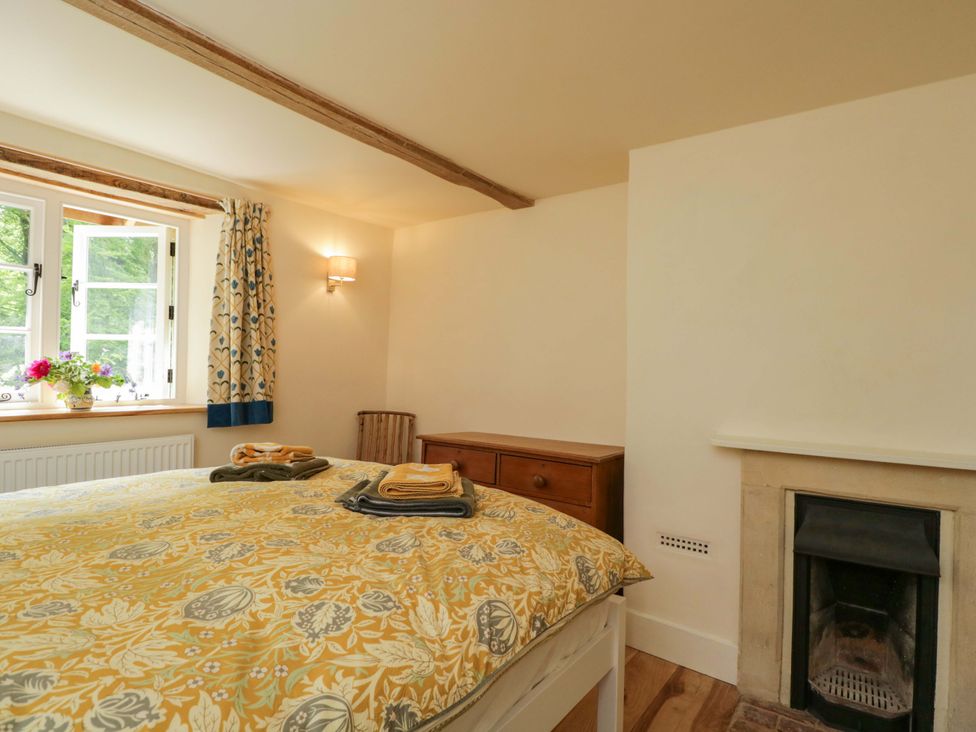 A bedroom with a bed and a window at Keepers Cottage in Devizes