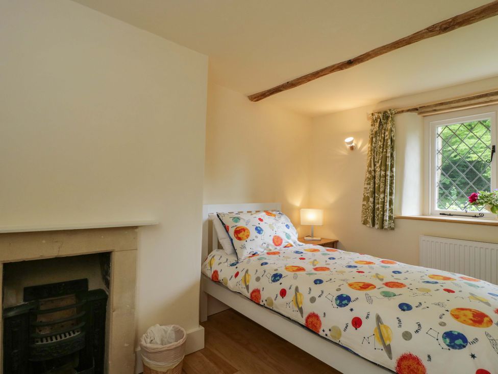 A bedroom with a bed and bedside lamp at Keepers Cottage in Devizes