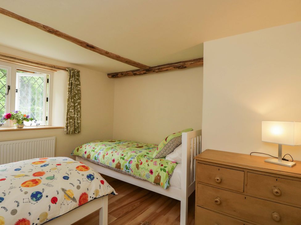 A bedroom with two beds and a dresser at Keepers Cottage in Devizes
