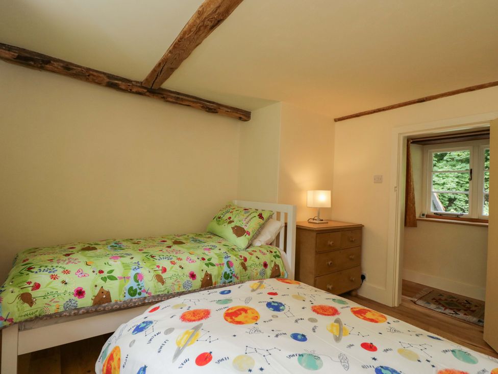A bedroom with two beds and a lamp at Keepers Cottage in Devizes