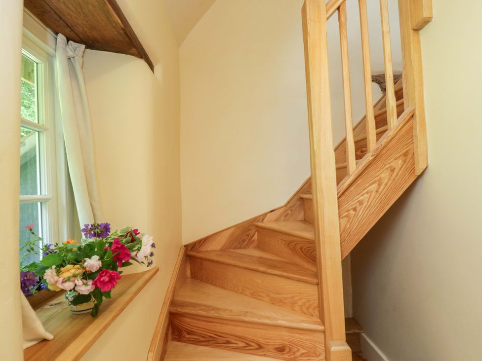A staircase with a window and flowers at Keepers Cottage in Devizes