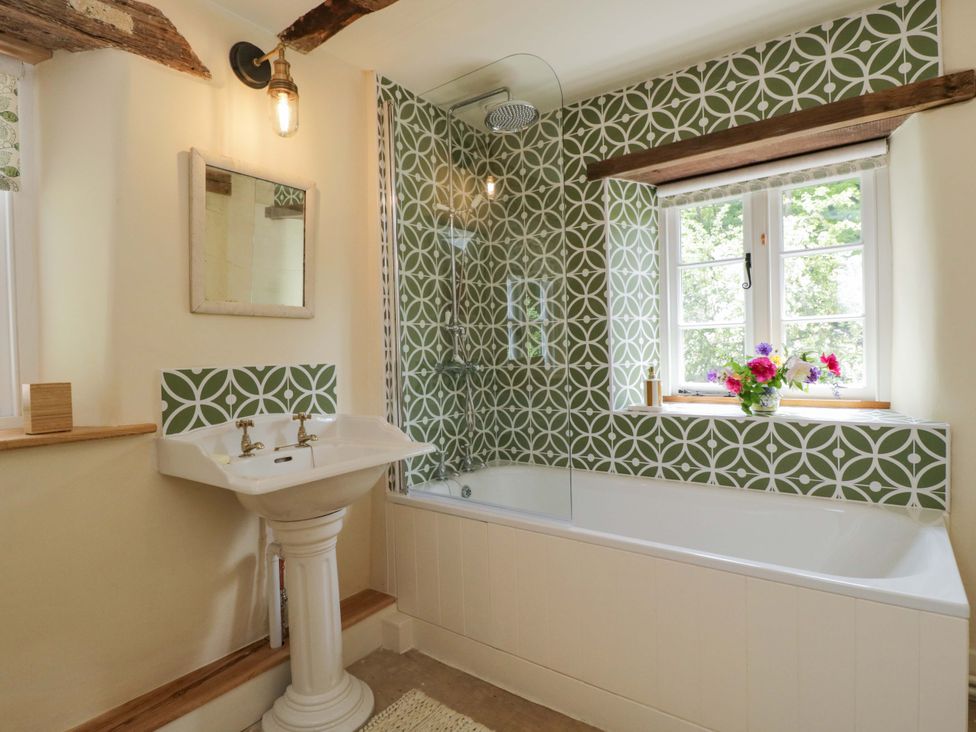 A bathroom with a bath tub and sink at Keepers Cottage in Devizes