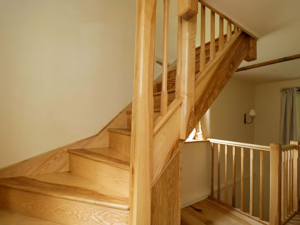 A staircase with wooden steps and handrail at Keepers Cottage in Devizes
