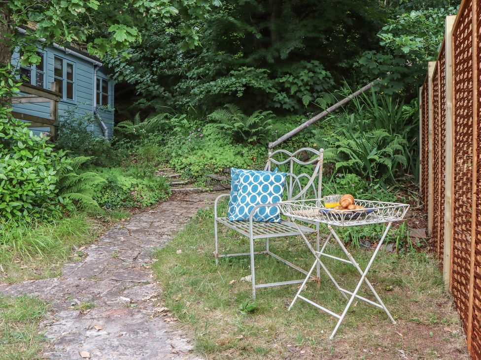 An outdoor seating area with a chair and table at The Boat House in Ashprington