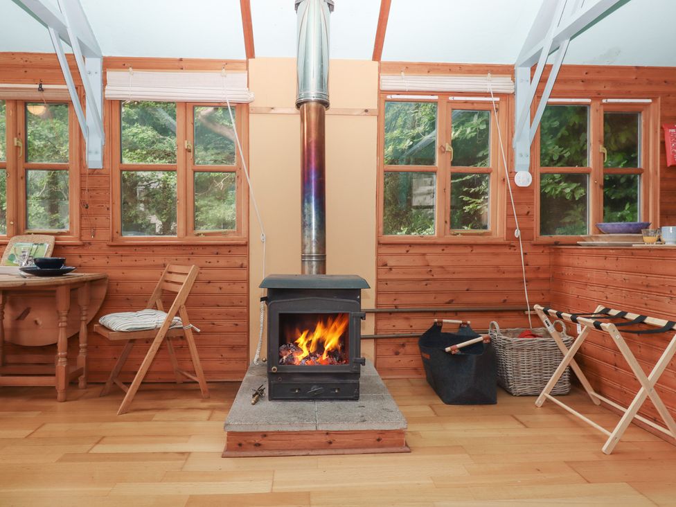 A living room with a wood stove and table at The Boat House in Ashprington