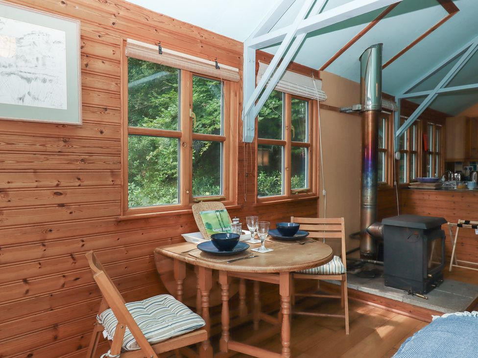 A dining area with a table and chairs at The Boat House in Ashprington