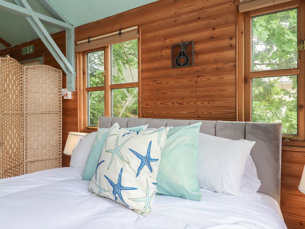 A bedroom with a bed and pillows at The Boat House in Ashprington