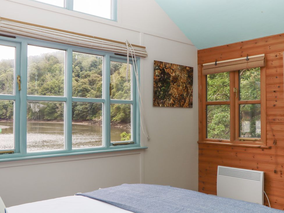 A bedroom with windows and a view at The Boat House in Ashprington
