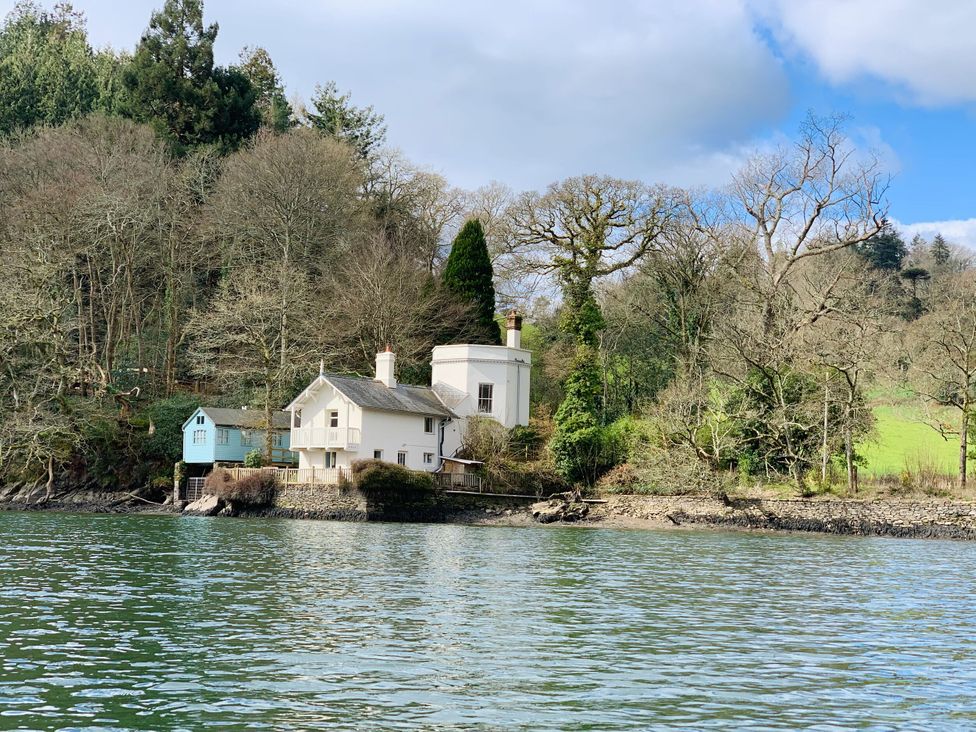 A house near water with trees surrounding it at The Boat House in Ashprington
