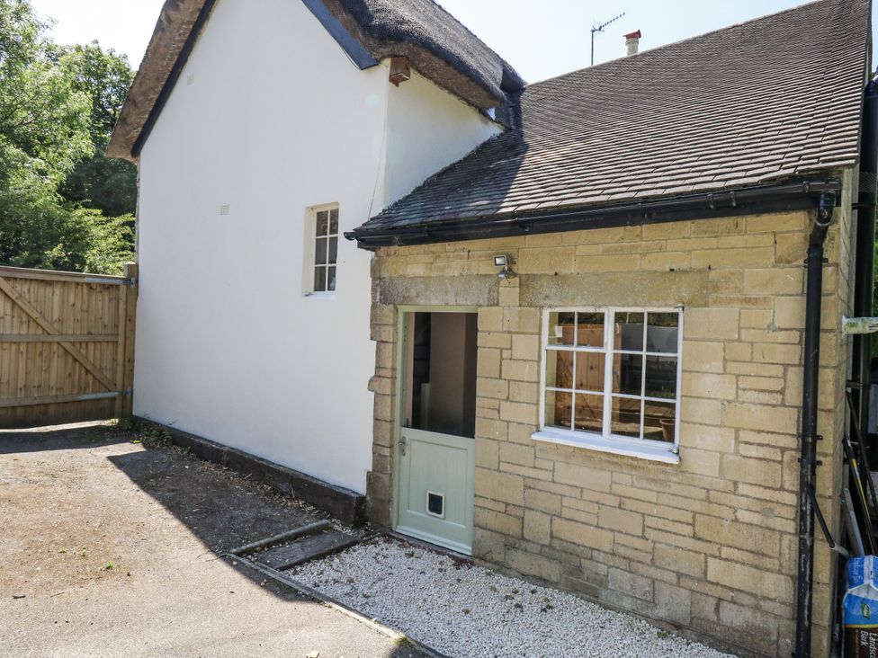 An outdoor area with a door and window at Happiness Cottage in Piddlehinton
