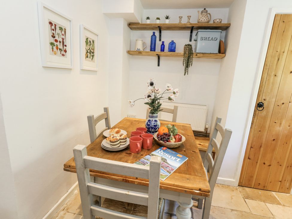 A dining room with a table set for breakfast at Happiness Cottage in Piddlehinton