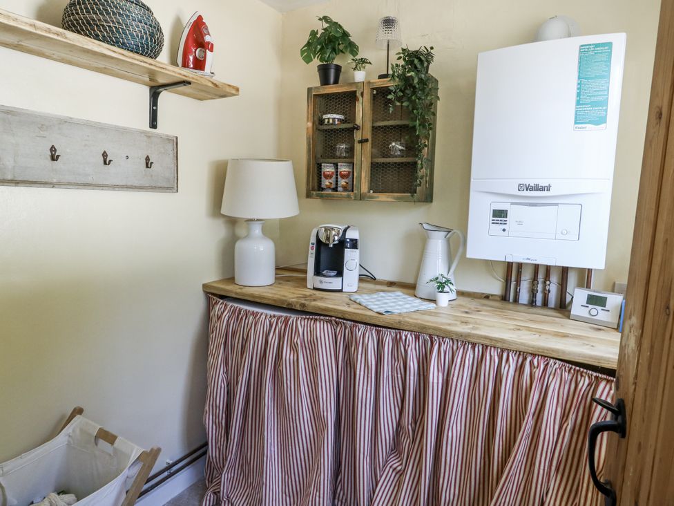 A utility room with boiler, coffee maker, and lamp at Happiness Cottage in Piddlehinton