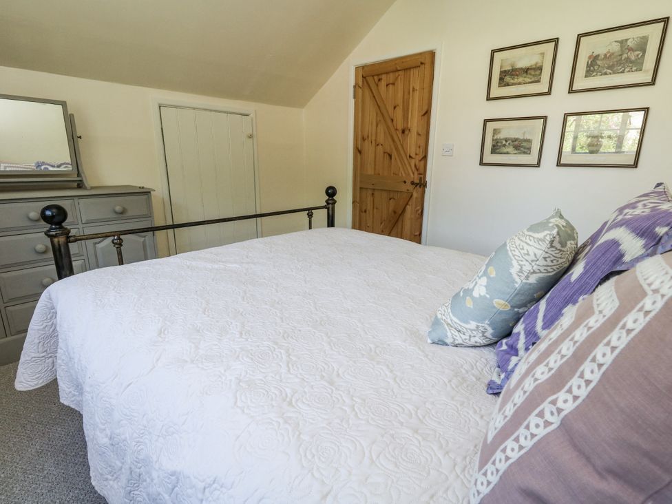 A bedroom with a bed and dresser at Happiness Cottage Piddlehinton