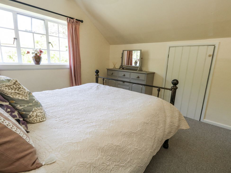 A bedroom with a bed and dresser at Happiness Cottage in Piddlehinton