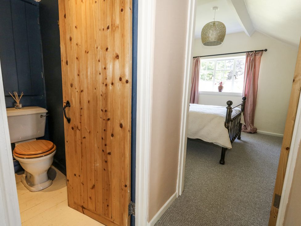 A bathroom with toilet and sink leading to a bedroom at Happiness Cottage in Piddlehinton
