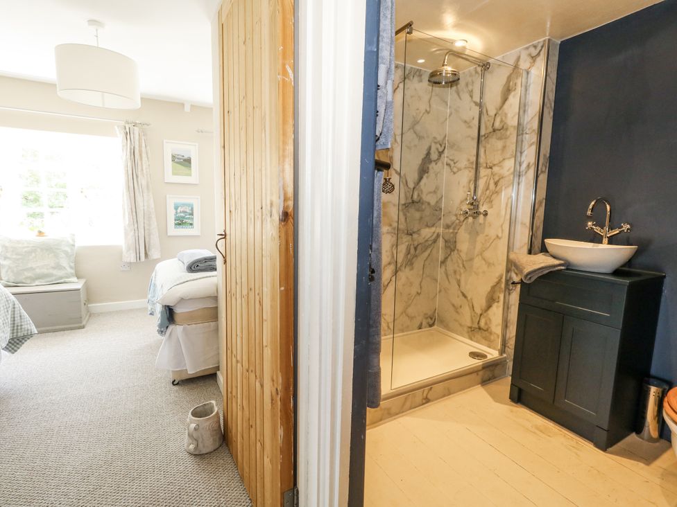 A bedroom with a shower and sink at Happiness Cottage Piddlehinton