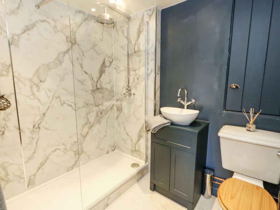 A bathroom with a shower and sink at Happiness Cottage in Piddlehinton