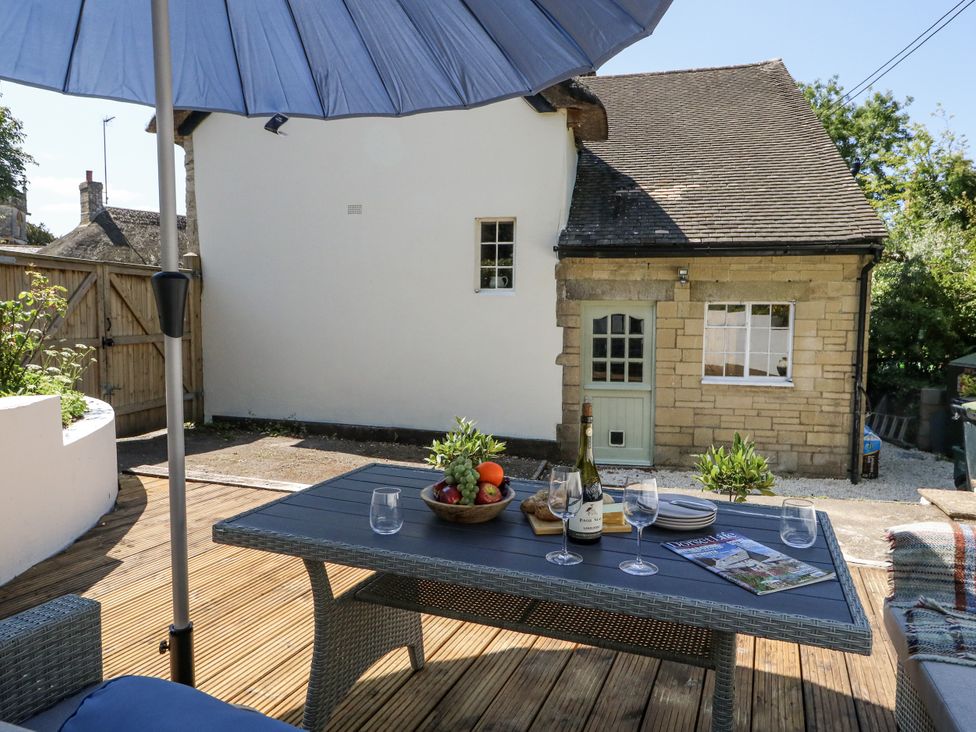 An outdoor area with a table and umbrella at Happiness Cottage in Piddlehinton