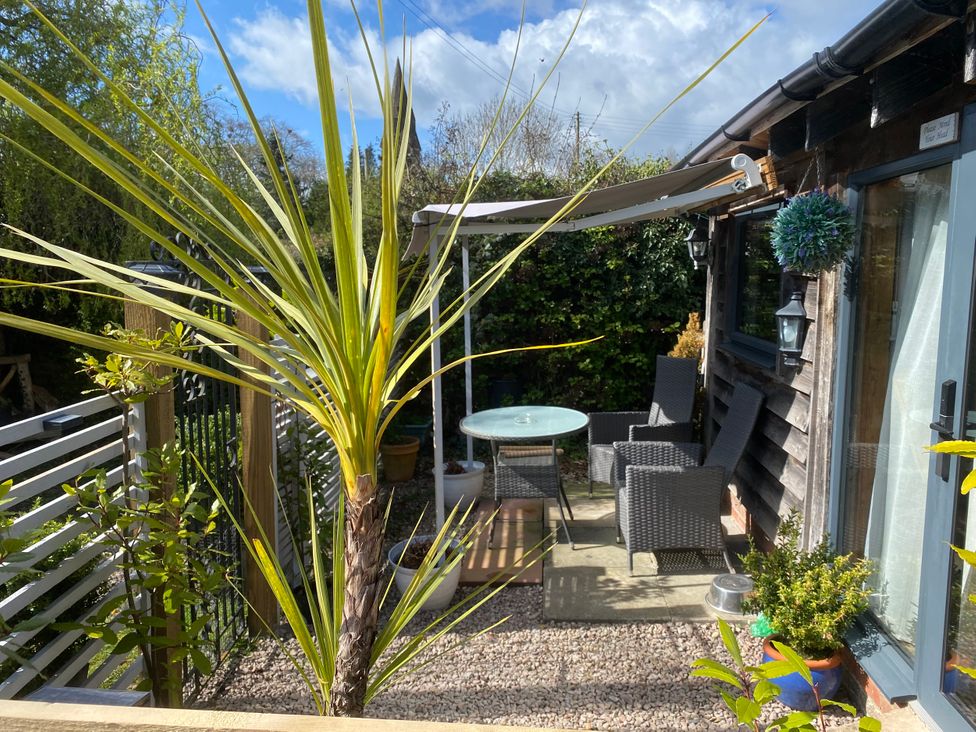 A garden with a table and chairs under an awning at The Pheasant's Nest in Welland near Upton Upon Severn