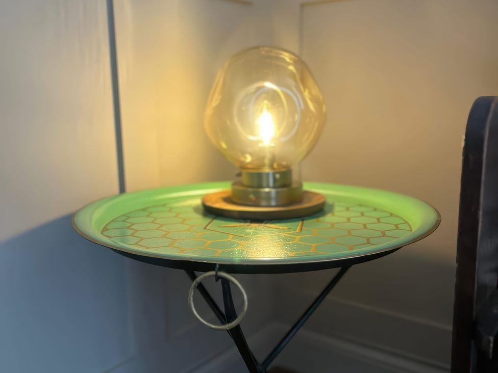 A side table with a lamp in a living room at Craster House in Seahouses