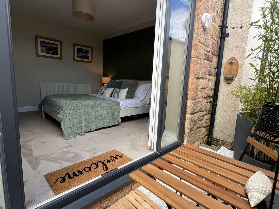 A bedroom with a bed and seating area at Craster House in Seahouses