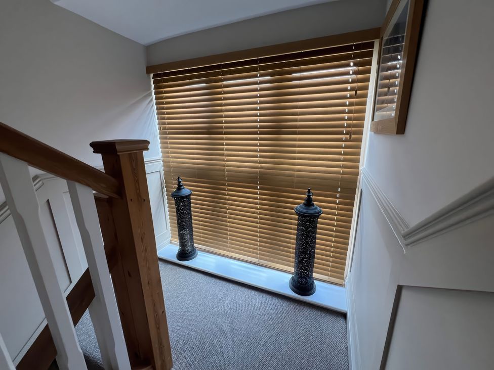 A hallway with decorative lanterns and window blinds at Craster House Seahouses