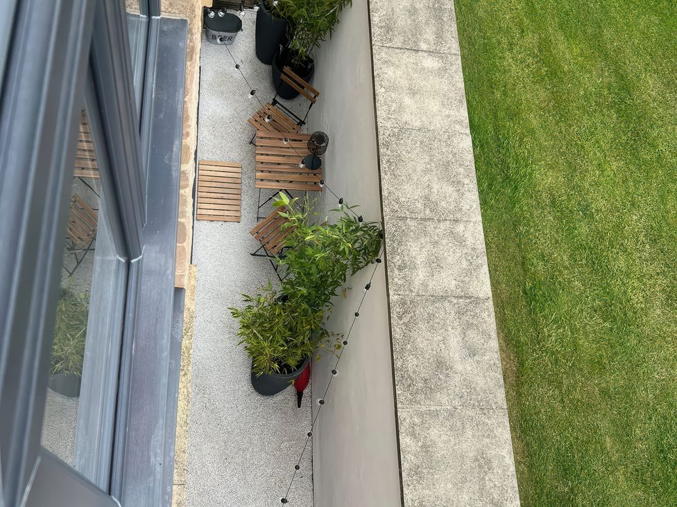 An outdoor seating area with chairs and a table at Craster House in Seahouses
